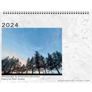 The front of the 2024 calendar showing a photo of a tree line inset over a map