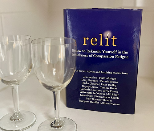 A hardcopy of RELIT ready for its launch party next to two empty wineglasses